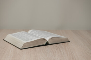 Aufkleber - Open holy bible on a  wooden table. Beautiful white wall background.
