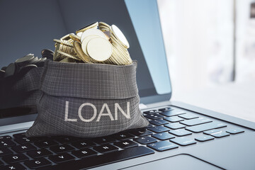 Bank loan and finance concept with metal coins in canvas loan bag on laptop keyboard