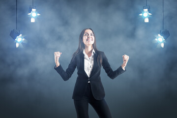 Successful businesswoman on abstract smoky background with spotlights on top