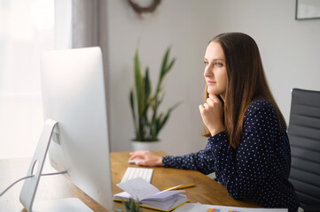 side view at the female employee working with a trendy pc in modern office. smart and confident woma