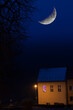 Duży księżyc na nocnym niebie nad domem, w którym pali się fioletowe światło.