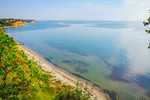 Cliff With Vegetation Above Idyllic And Peaceful Bay
