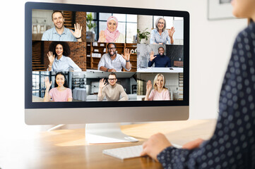 Online video discussion with many people together. Young woman sits in front of laptop with many icons, photo profiles of people on screen. App for video meeting with diverse team