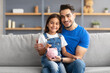 © Prostock-studio - Little girl and dad saving money in piggy bank