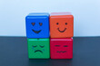 Different emotions concept, funny faces drawn on cubes.
