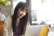 © dodotone - Young adult asian college student woman using laptop study and work at cafe.