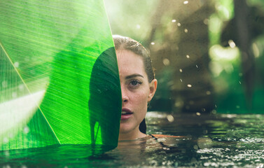 Beautiful girl relaxing outdoor in her garden with swimming pool. Summer concept about lifestyle,beauty, vacations and real estates