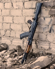 
AK-47 leaning against a brick wall