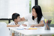 © aedkafl - Mother and son doing homework at home, Mother is teaching son to draw pictures, Children homework. Young boy doing homework on the terrace at home. Happy mood. Back to school concept.
