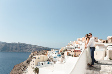 Happy couple hugging and laughing together with a view of Santorini