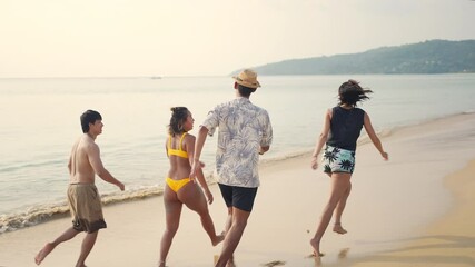 Wall Mural - 4K Group of Happy Asian man and woman friends running and playing together on tropical beach in sunny day. Male and female friendship enjoy and having fun outdoor lifestyle activity on summer vacation