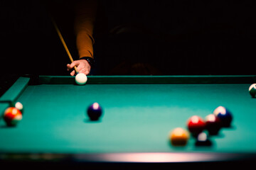 billiard green table in hall with white balls with men hand