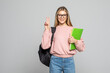 © dianagrytsku - Young student woman doing peace sign with fingers, excellent symbol wearing backpack holding books over isolated white background