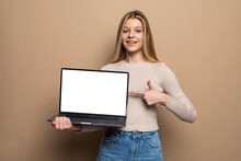Happy Young Woman Showing Blank Screen Laptop Computer Isolated Over Beige Background