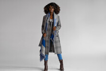 Female Black Model Wear Grey Plaid Coat With Scarf With A Trendy Afro Hairstyle Isoalted On Gray