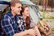 © Ryzhkov Oleksandr - Romantic couple camping outdoors and sitting in a tent.