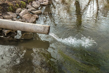 Sewer Drains From A Pipe Into A River In The City