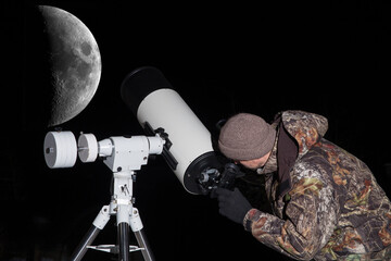 Wall Mural - a european man looks at the moon through a telescope. dark background.