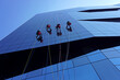 Window cleaners abseiling down the exterior of an office building in Rome, Italy.