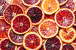 Bright colorful background of fresh ripe sliced blood oranges. Close up, flat lay. Orange texure, top view