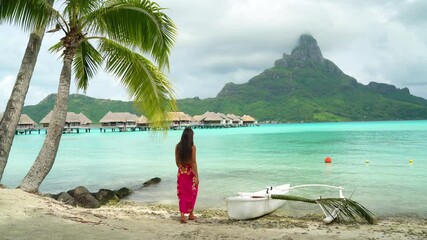 Wall Mural - Bora Bora Vacation Travel woman walking on paradise motu beach on in French Polynesia with Mount Otemanu by traditional canoe outrigger vaa. Lady on luxury holiday in overwater bungalow resort hotel