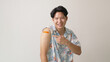 © ChayTee - Adult mature attractive handsome asia hipster male after shot receive covid-19 anti virus vaccine in campaign vaccination safe life happy smile cheerful with bandage on arm with copy space.