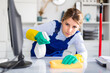 © JackF - Woman in an overalls cleans the table at office