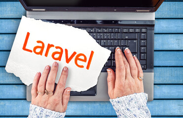 Laravel PHP Framework programming language. Word Laravel on paper and laptop
