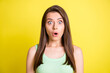 © deagreez - Photo of young shocked amazed surprised girl in green singlet hear unexpected news isolated on yellow color background