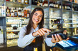 © Graphicroyalty - Contactless payment concept, female holding terminal nfc technology on counter, client make transaction pay bill on terminal rfid cashier machine in restaurant store, close up view