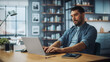 © Gorodenkoff - Handsome Caucasian Man Working on Laptop Computer while Sitting on a Sofa Couch in Stylish Cozy Living Room. Freelancer Working From Home. Browsing Internet, Using Social Networks, Being Serious.