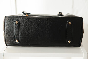 bottom of a black leather women's bag on a white background