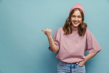 Young happy woman smiling and pointing finger aside