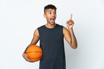 Young Brazilian man over isolated background playing basketball and having an idea