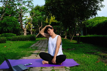 Asian women exercise by doing yoga in the park.