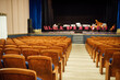 © evgavrilov - an empty concert hall with free upholstered chairs. musical instruments lie on the stage among the chairs waiting for the orchestra. no audience at the event
