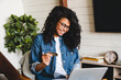 © InsideCreativeHouse - Cheerful african young woman doing online shopping at home using laptop and credit card. African-american woman doing orders through the Internet