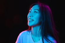 Asian Young Woman's Portrait On Dark Studio Background In Neon. Concept Of Human Emotions, Facial Expression, Youth, Sales, Ad.