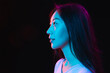 © master1305 - Asian young woman's portrait on dark studio background in neon. Concept of human emotions, facial expression, youth, sales, ad.