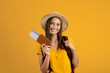 © Prostock-studio - Cheerful woman backpacker with passport and flight tickets