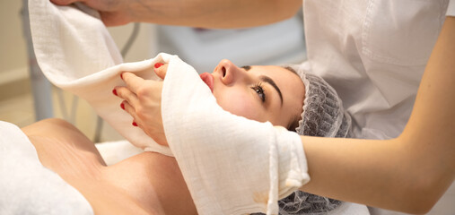 Wall Mural - Relaxed young woman lying on spa bed prepared for facial treatment and massage in luxury spa resort. Wellness, stress relief and rejuvenation concept.