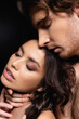 © LIGHTFIELD STUDIOS - passionate man touching neck of seductive woman isolated on black.