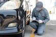 © photobuay - A Young Mechanic Writing On Clipboard Examining Car Wheel