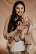 © Ananass - portrait of a cute baby and her mom holding a baby in her mother's arms