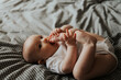 © Ananass - Beautiful cute baby lying and playing on the bed in the room, photo with daylight from the window