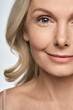 © insta_photos - Face close up portrait of happy smiling mid age 50 years old woman isolated on white background. Advertising of facial skin care anti wrinkle tightening lift products for women in menopause.