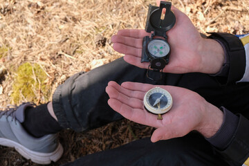 Male palms holding two compasses. Choice concept. Selective focus. Copy space. 