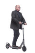 © ASDF - side view . Mature man with electric scooter looking forward