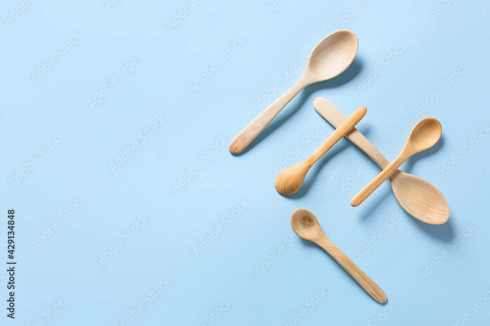 Wooden spoons on color background