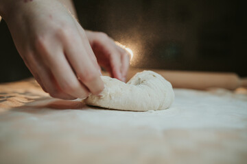 Wall Mural - Person preparing a dough with hands and flour